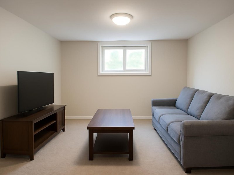 AI concept: A finished basement apartment living room with a sofa, plain undecorated walls and a daylight window