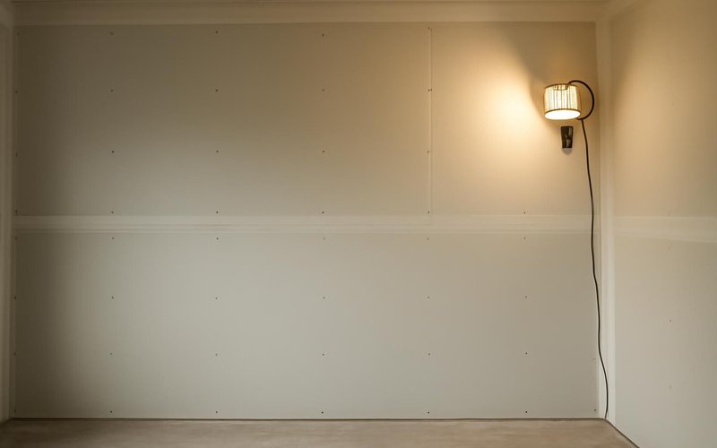AI concept: Smooth primed drywall wall under a work light