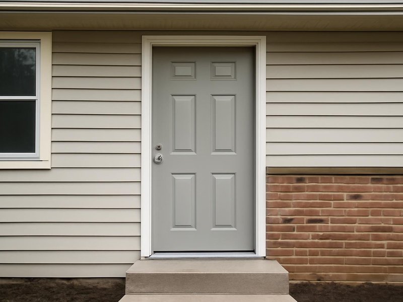 AI concept: Existing condition: dented steel door with no glass on a split-level