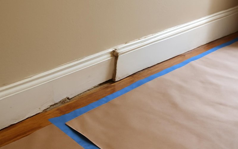 AI concept: Old baseboard being removed with floors protected