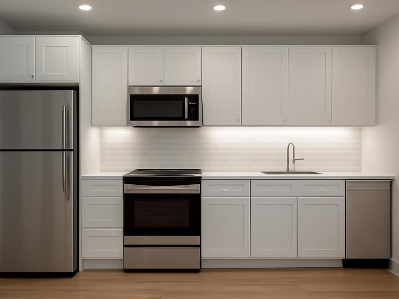 After: same kitchen with recessed lights and under-cabinet LEDs
