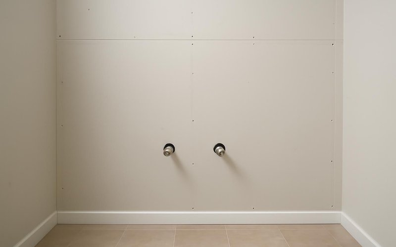 AI concept: A framed bathroom wall with neatly installed capped plumbing supply stub-outs and no workers