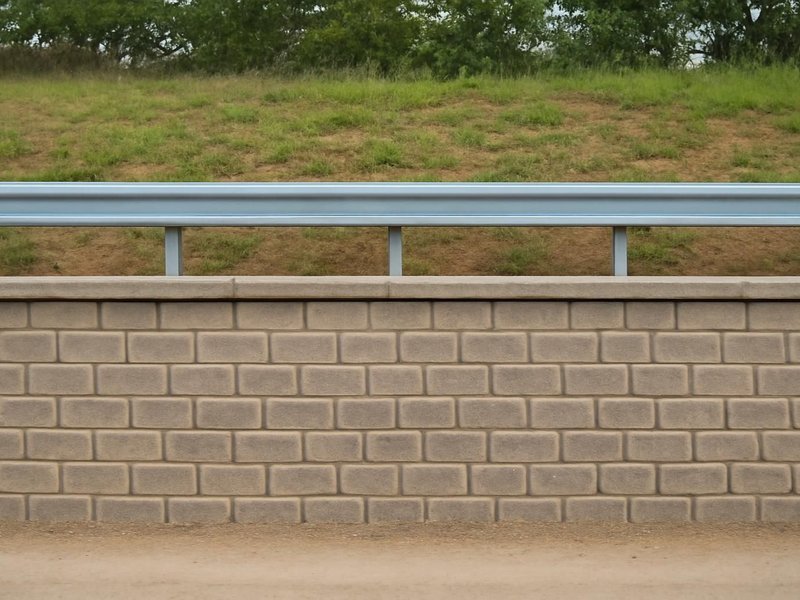 After: engineered block wall with a guardrail along the top