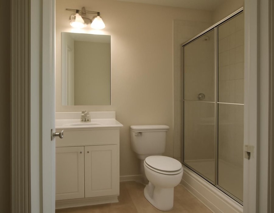AI concept: One compact American bathroom with a single vanity, toilet and glass shower, photographed from the doorway