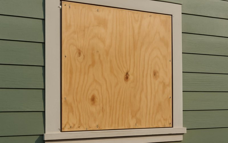 AI concept: Plywood screwed over a broken window
