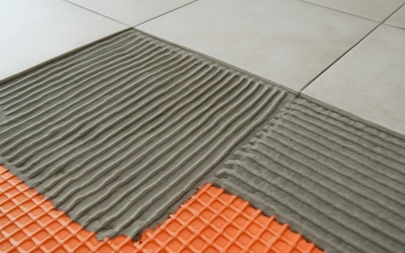 Thinset mortar troweled onto a floor membrane