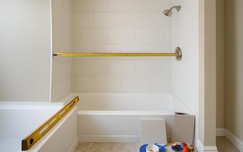 AI concept: Supervisor measuring a tub alcove for a shower conversion